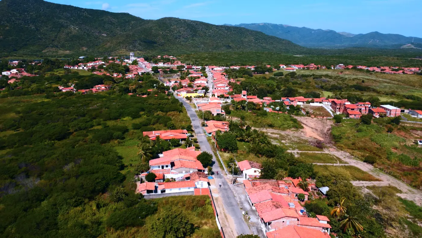 Avenida atravessando bairros de Maranguape em direção à serra verde no horizonte